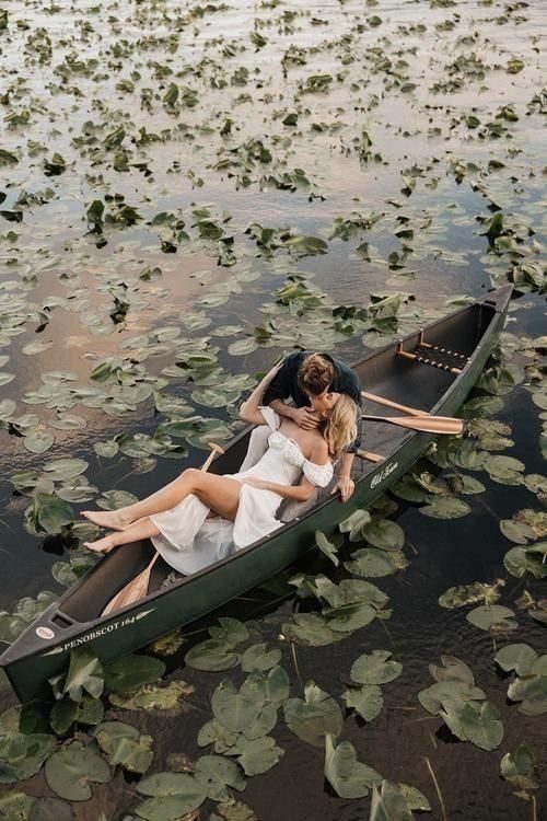 A couple in a canoe among the lily pads