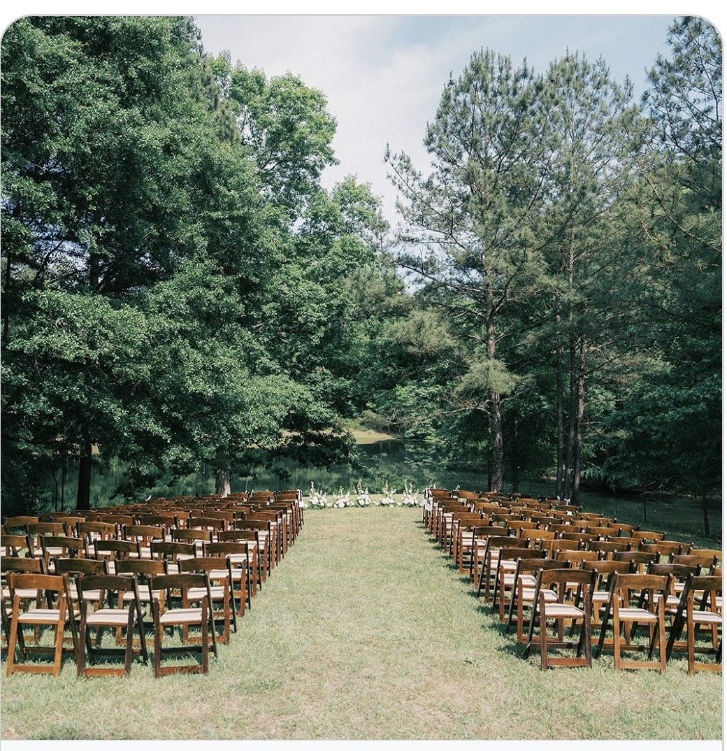 The lakefront ceremony — wooden chairs facing the water through the pines